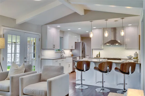 a kitchen with cabinets and chairs