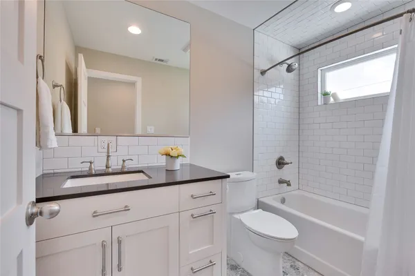a bathroom with a granite countertop sink toilet and shower