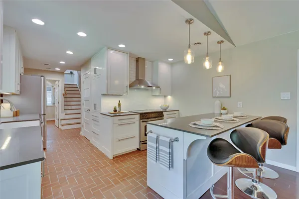 a kitchen with kitchen island stainless steel appliances a stove a sink and a refrigerator
