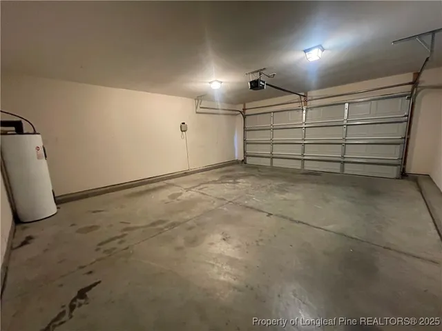 an empty room with windows and chandelier fan
