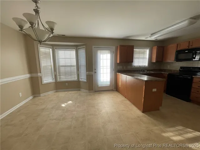 a large kitchen with kitchen island granite countertop a sink and a stove top oven