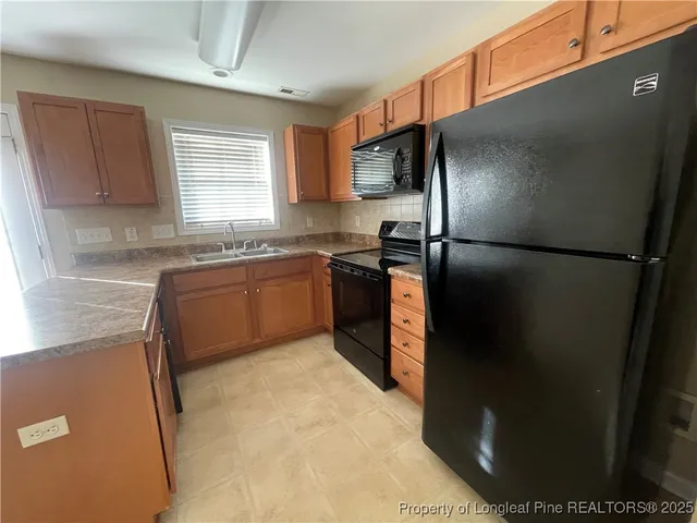 a kitchen with stainless steel appliances granite countertop a refrigerator a sink a stove and island