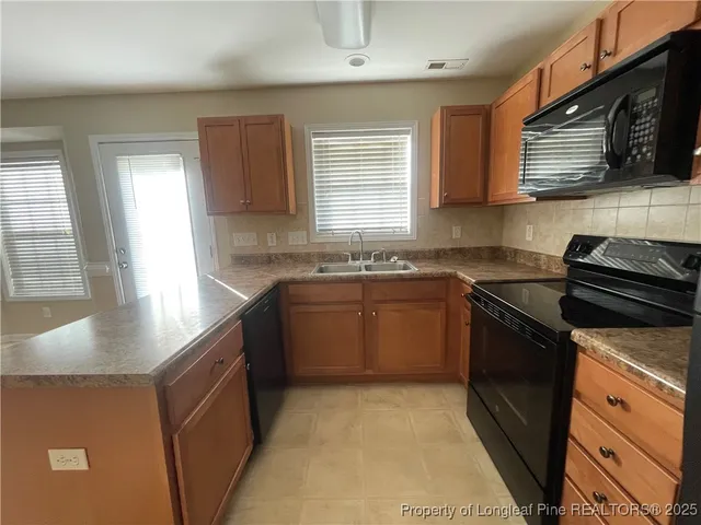 a kitchen with stainless steel appliances granite countertop a sink stove and microwave