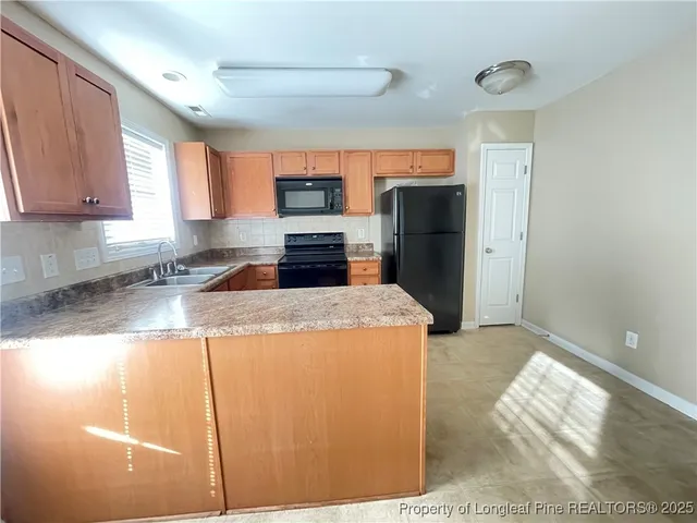 a kitchen with stainless steel appliances granite countertop a refrigerator a stove top oven a sink and dishwasher