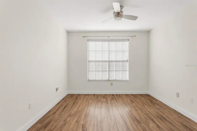 an empty room with a window and wooden floor