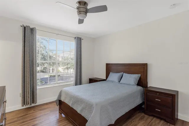 a bedroom with a large bed and wooden floor