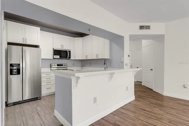 a view of kitchen with stainless steel appliances a refrigerator and a stove top oven