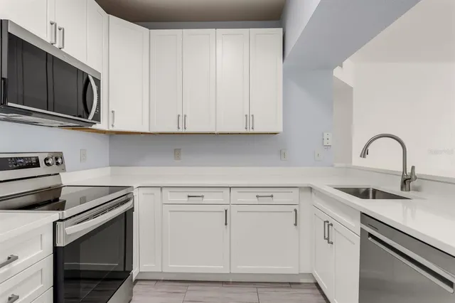a kitchen with white cabinets and stainless steel appliances