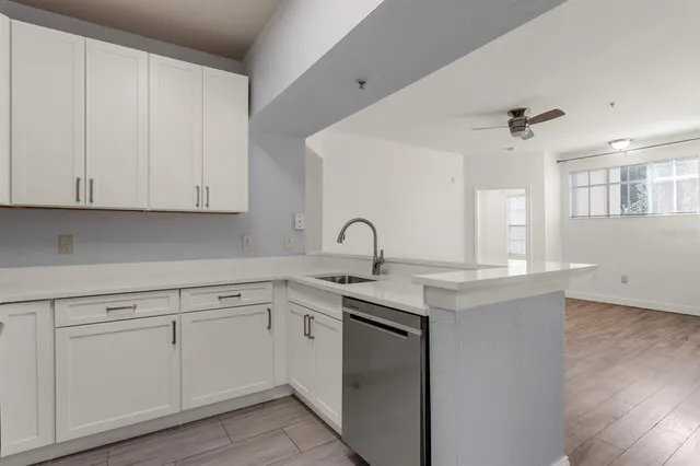 a kitchen with white cabinets appliances and sink
