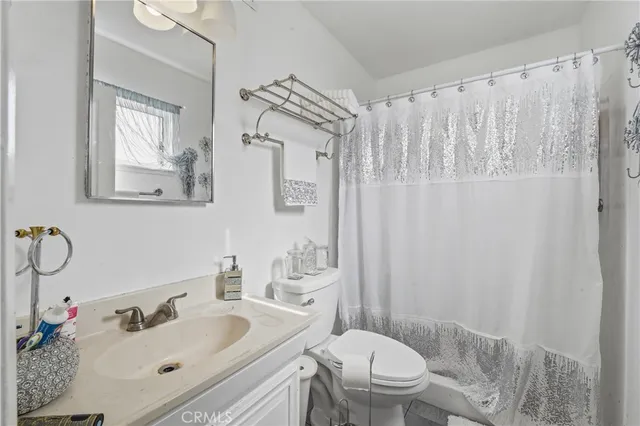 a bathroom with a sink a toilet and shower curtain