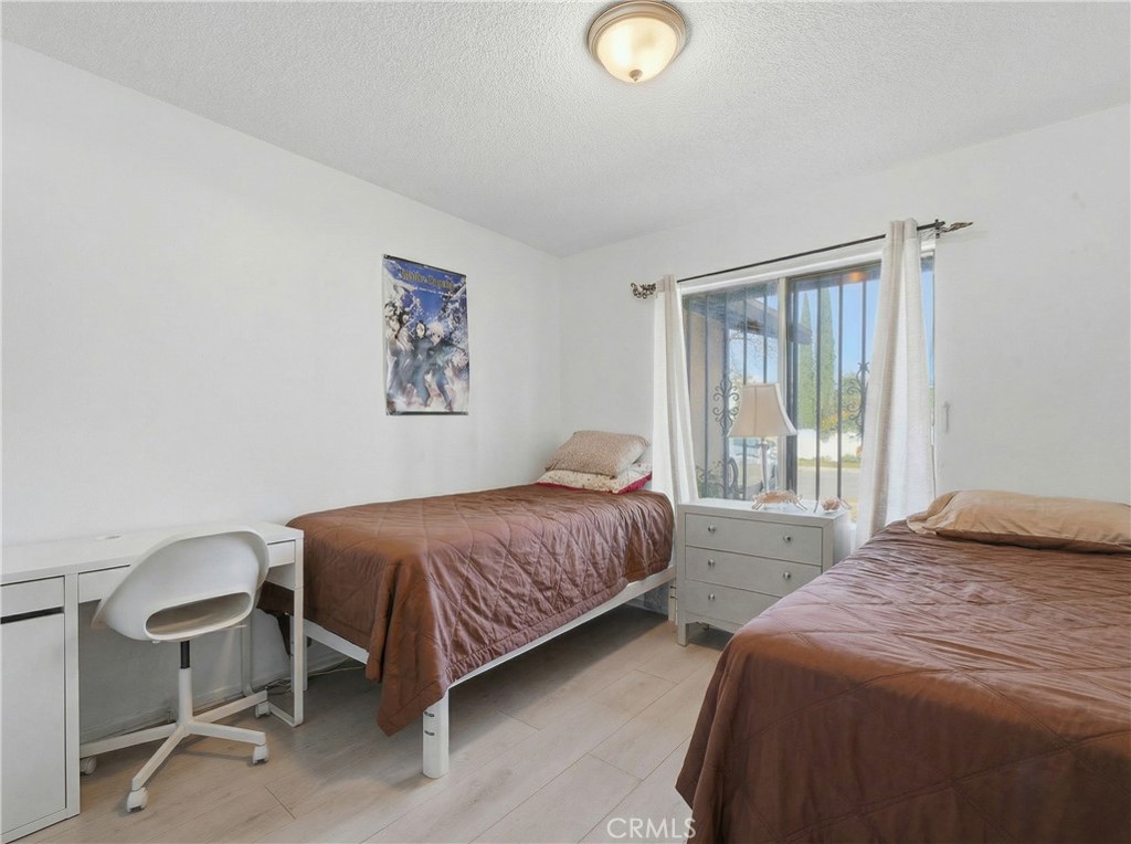 645 West Winchester Drive Rialto, CA 92376 - Photo 15 of 22 a bedroom with a bed lamp and a window