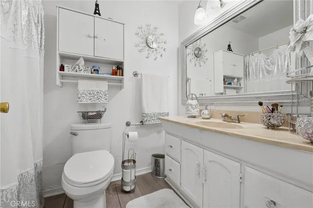 a bathroom with a granite countertop toilet sink and a mirror