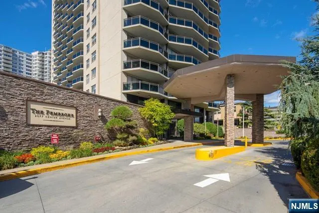 a view of a building with swimming pool and sitting area