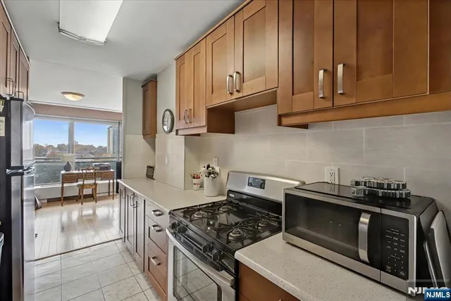 a kitchen with granite countertop a stove and a wooden cabinets