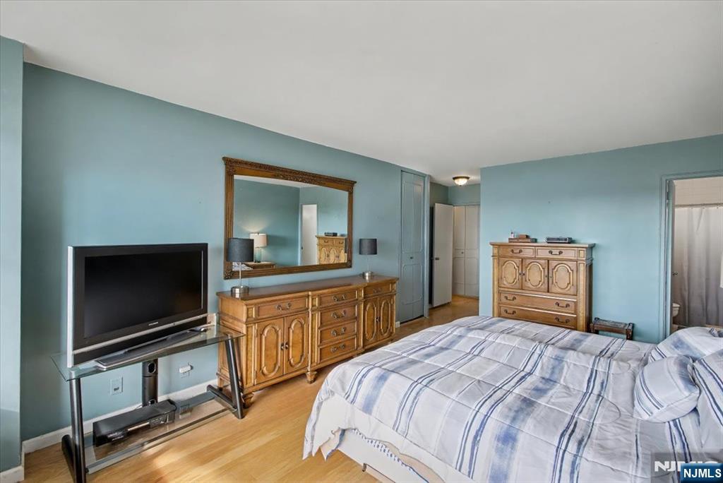 2077 Center Street, Unit 9B Fort Lee, NJ 07024 - Photo 10 of 17 a bedroom with a bed and a flat screen tv