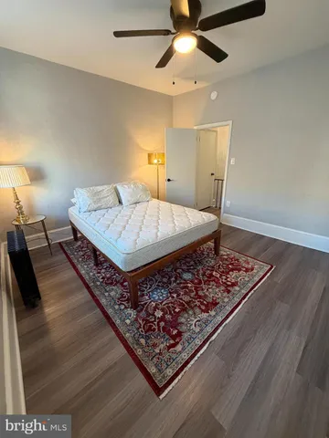 a bed sitting in a spacious bedroom next to a lamp