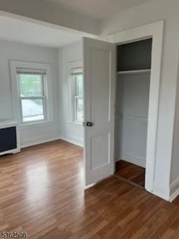 an empty room with wooden floor and closet