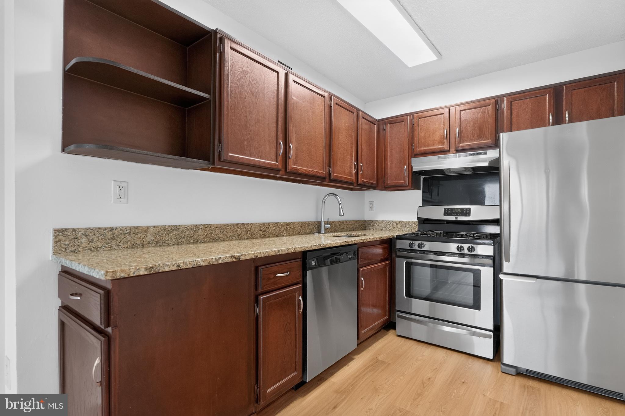 5225 Pooks Hill Road, Unit 1302N Bethesda, MD 20814 - Photo 12 of 19 a kitchen with stainless steel appliances granite countertop a stove microwave refrigerator and sink