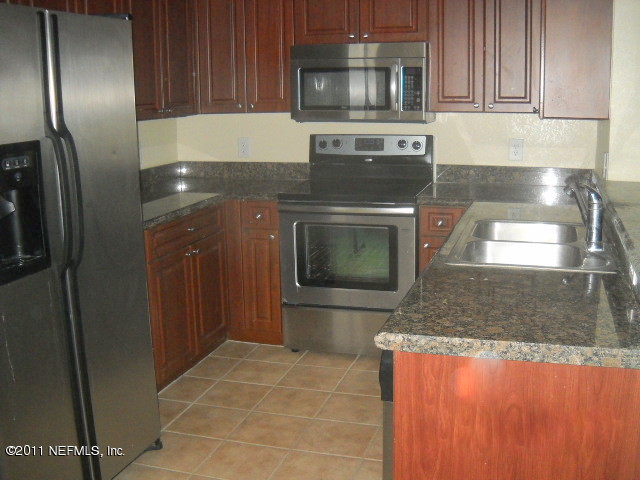 9745 Touchton Road, Unit 2403 Jacksonville, FL 32246 - Photo 3 of 9 a kitchen with stainless steel appliances granite countertop a refrigerator and a stove