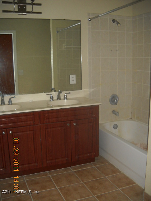 9745 Touchton Road, Unit 2403 Jacksonville, FL 32246 - Photo 8 of 9 a bathroom with a tub sink and mirror