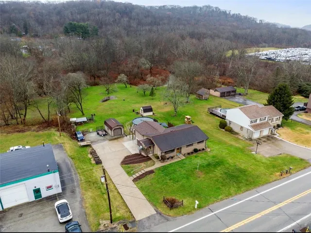 an aerial view of a house with garden space and mountain view in back