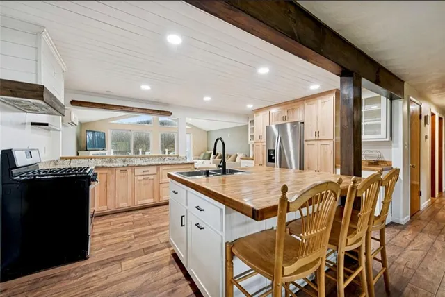a kitchen with stainless steel appliances granite countertop a sink and a refrigerator