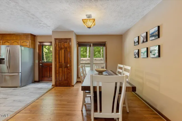 a kitchen with granite countertop stainless steel appliances a refrigerator cabinets and wooden floor