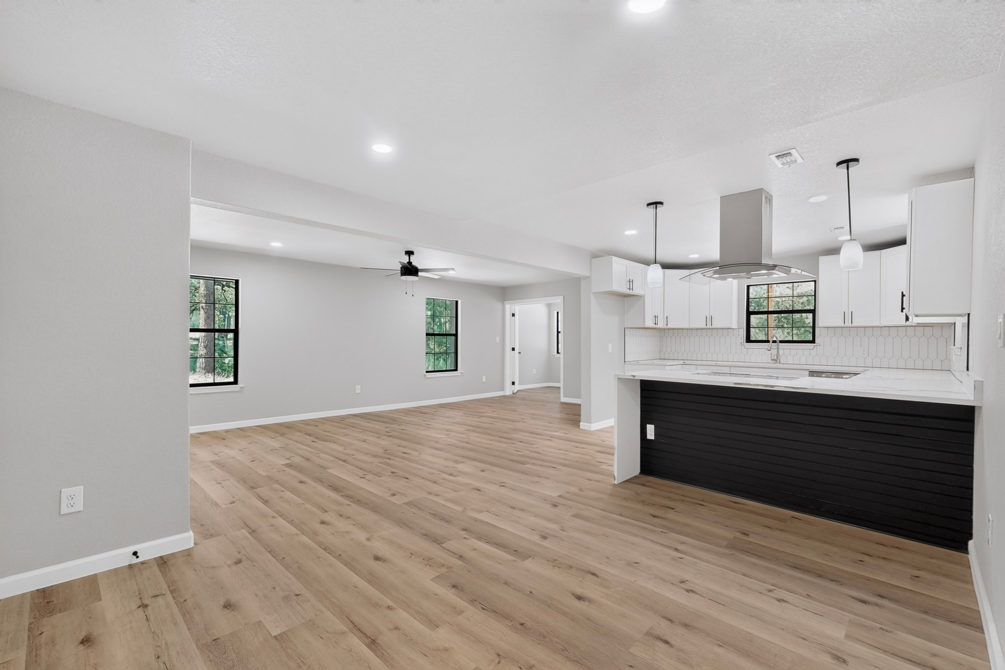 158 Fealy Road Red Rock, TX 78662 - Photo 12 of 40 Gleaming wood-look floors anchor this airy, open-concept living area and kitchen combination.