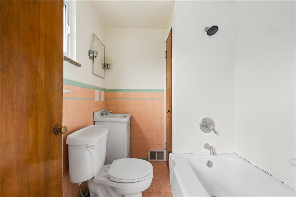 105 Delafield Road Pittsburgh, PA 15215 - Photo 15 of 18 a white toilet sitting next to a bathroom sink and vanity