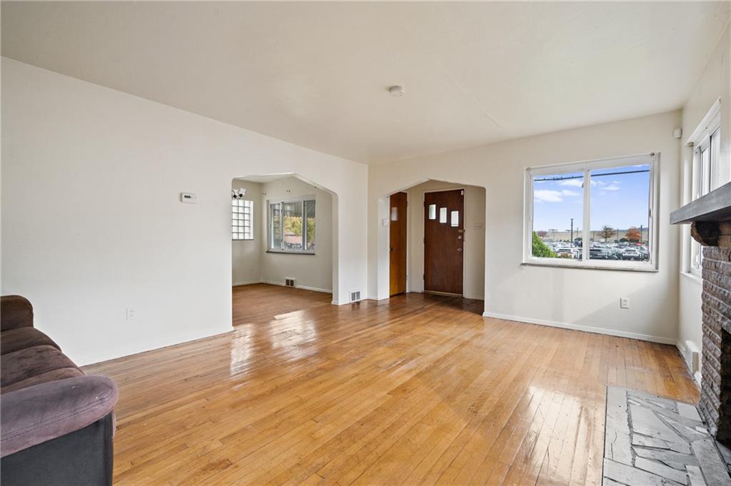 105 Delafield Road Pittsburgh, PA 15215 - Photo 6 of 18 a view of an empty room with window and wooden floor