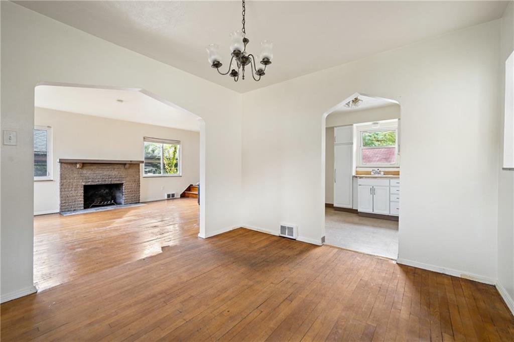 105 Delafield Road Pittsburgh, PA 15215 - Photo 9 of 18 a view of a livingroom with a fireplace a chandelier and wooden floor