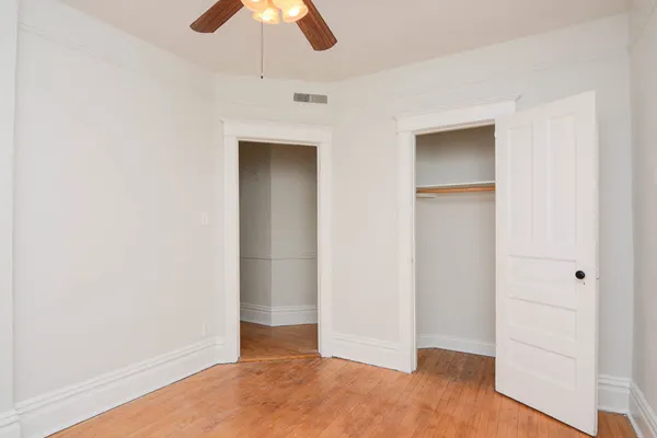 an empty room with ceiling fan and window