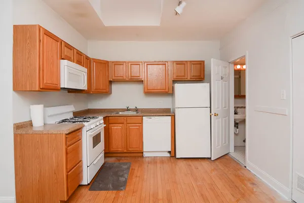 a kitchen with stainless steel appliances granite countertop a refrigerator a stove a sink and a microwave