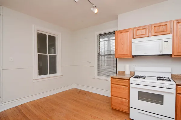 a kitchen with stainless steel appliances white cabinets and a wooden floor