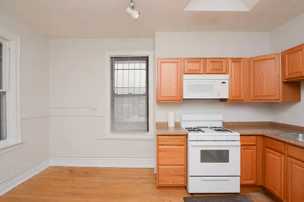 a kitchen with white cabinets and white appliances