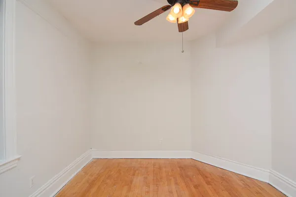 a view of a small space with wooden floor and a window