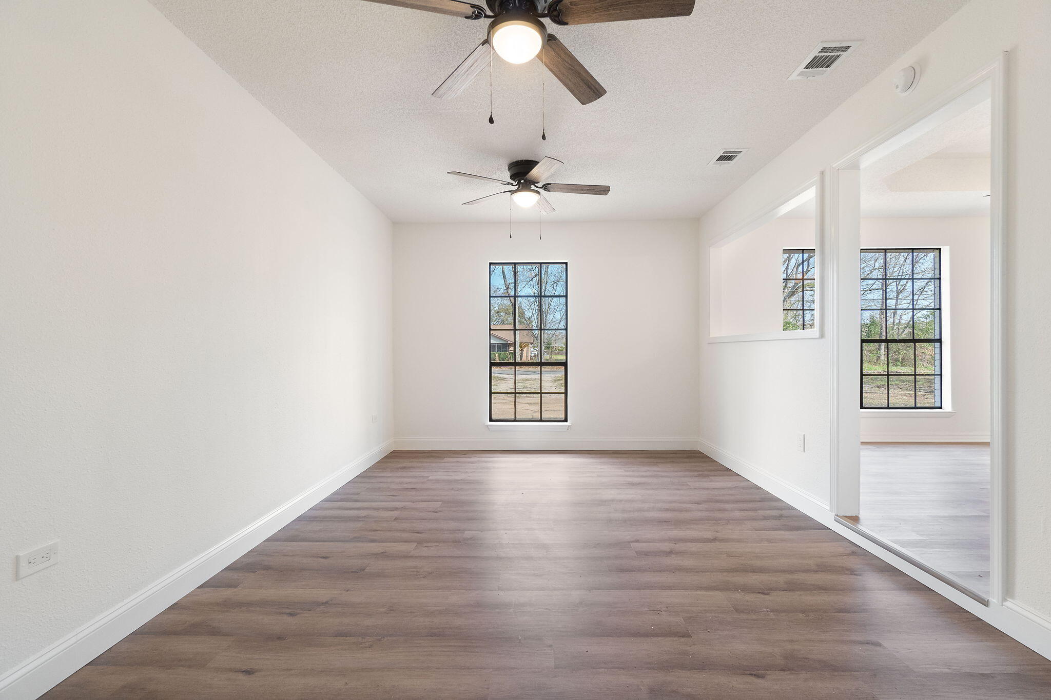 6118 Buckward Road Baker, FL 32531 - Photo 3 of 39 an empty room with wooden floor chandelier fan and windows