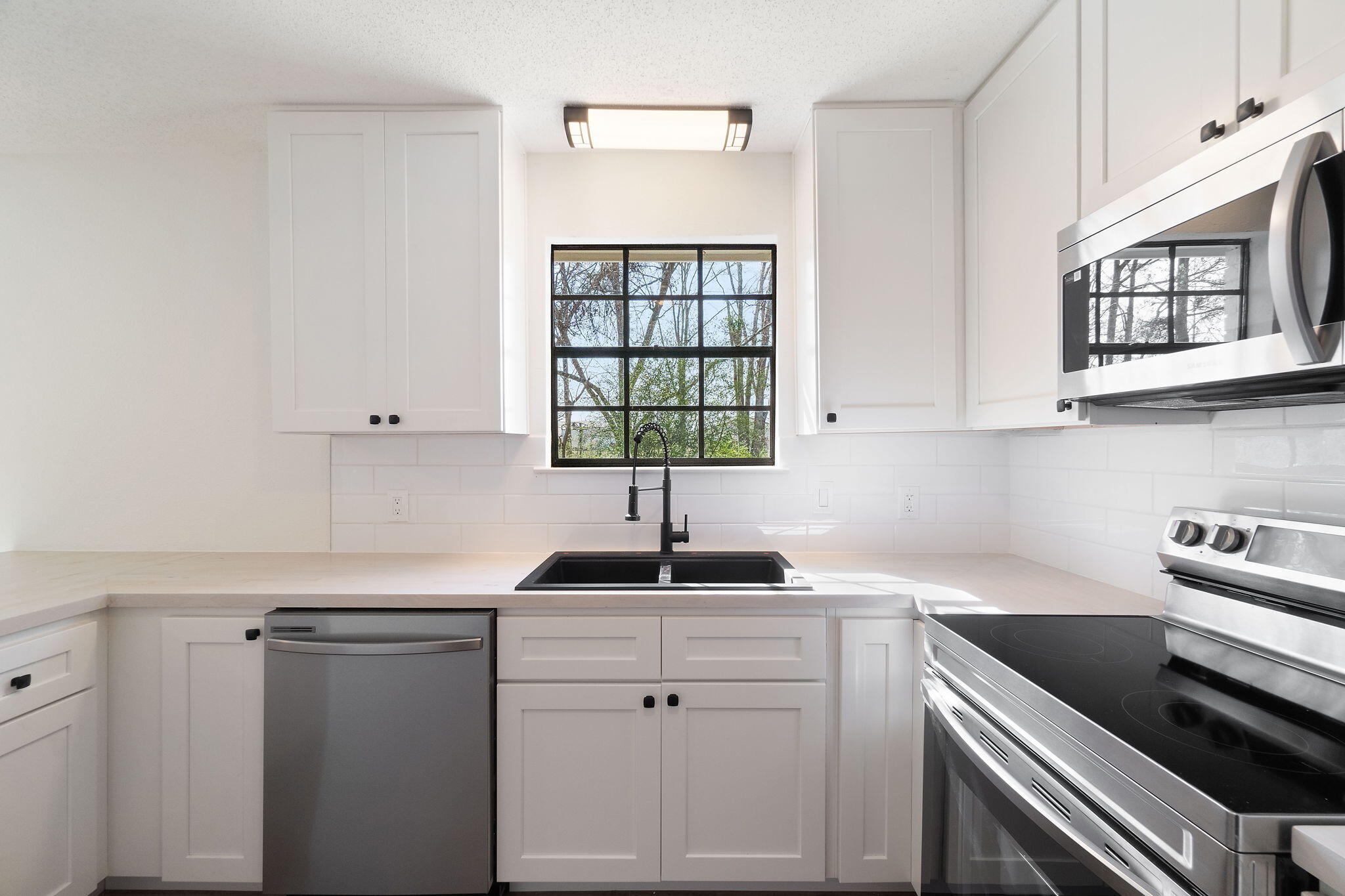 6118 Buckward Road Baker, FL 32531 - Photo 4 of 39 a kitchen with stainless steel appliances white cabinets and a window