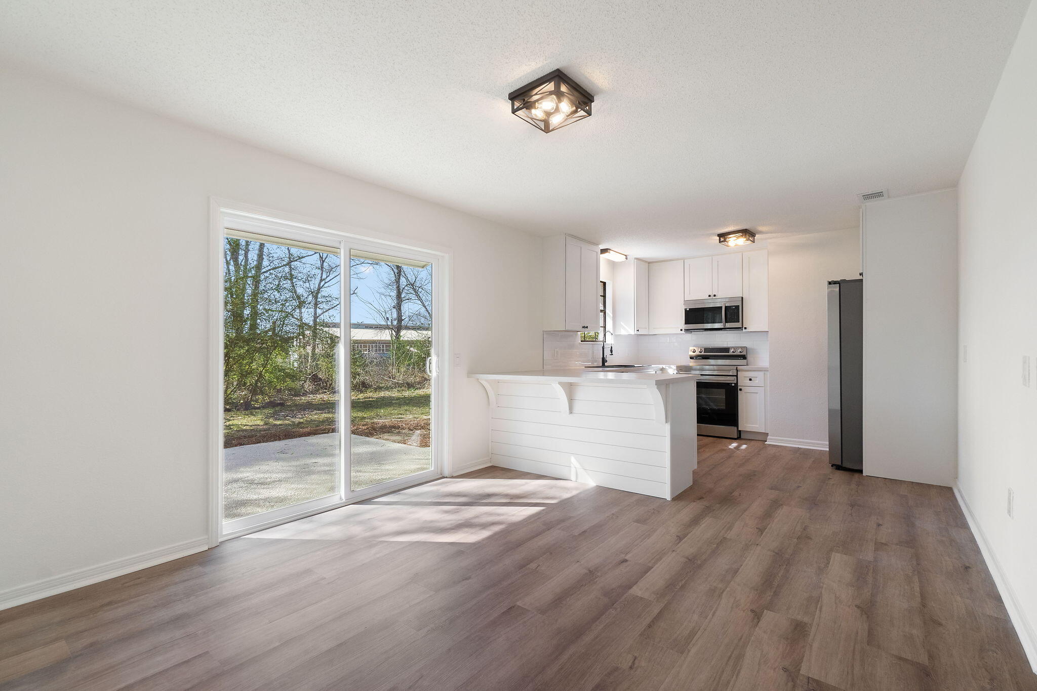 6118 Buckward Road Baker, FL 32531 - Photo 6 of 39 a view of a kitchen with wooden floor and electronic appliances