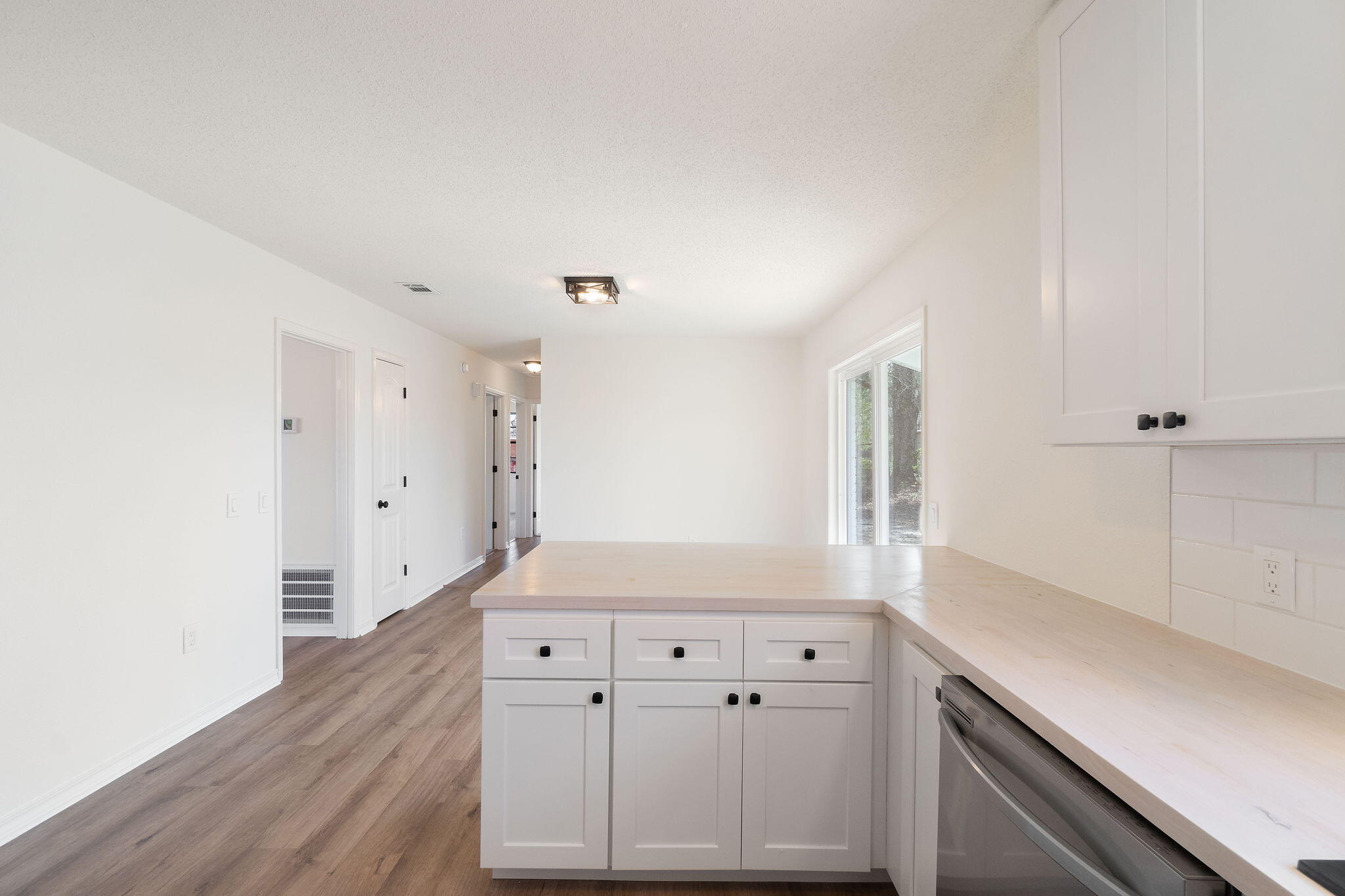 6118 Buckward Road Baker, FL 32531 - Photo 10 of 39 a kitchen with granite countertop white cabinets and a wooden floor
