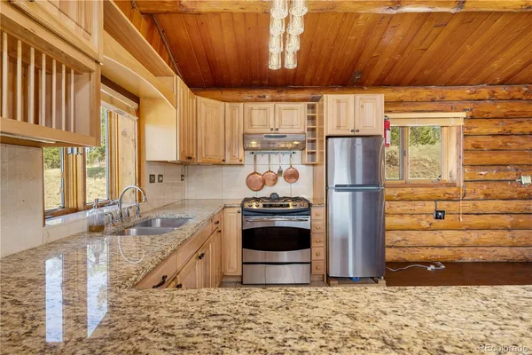 a kitchen with granite countertop a refrigerator and a sink