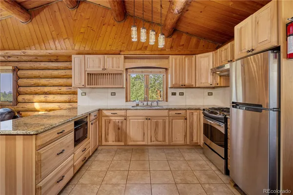 a kitchen with stainless steel appliances granite countertop a sink window and cabinets