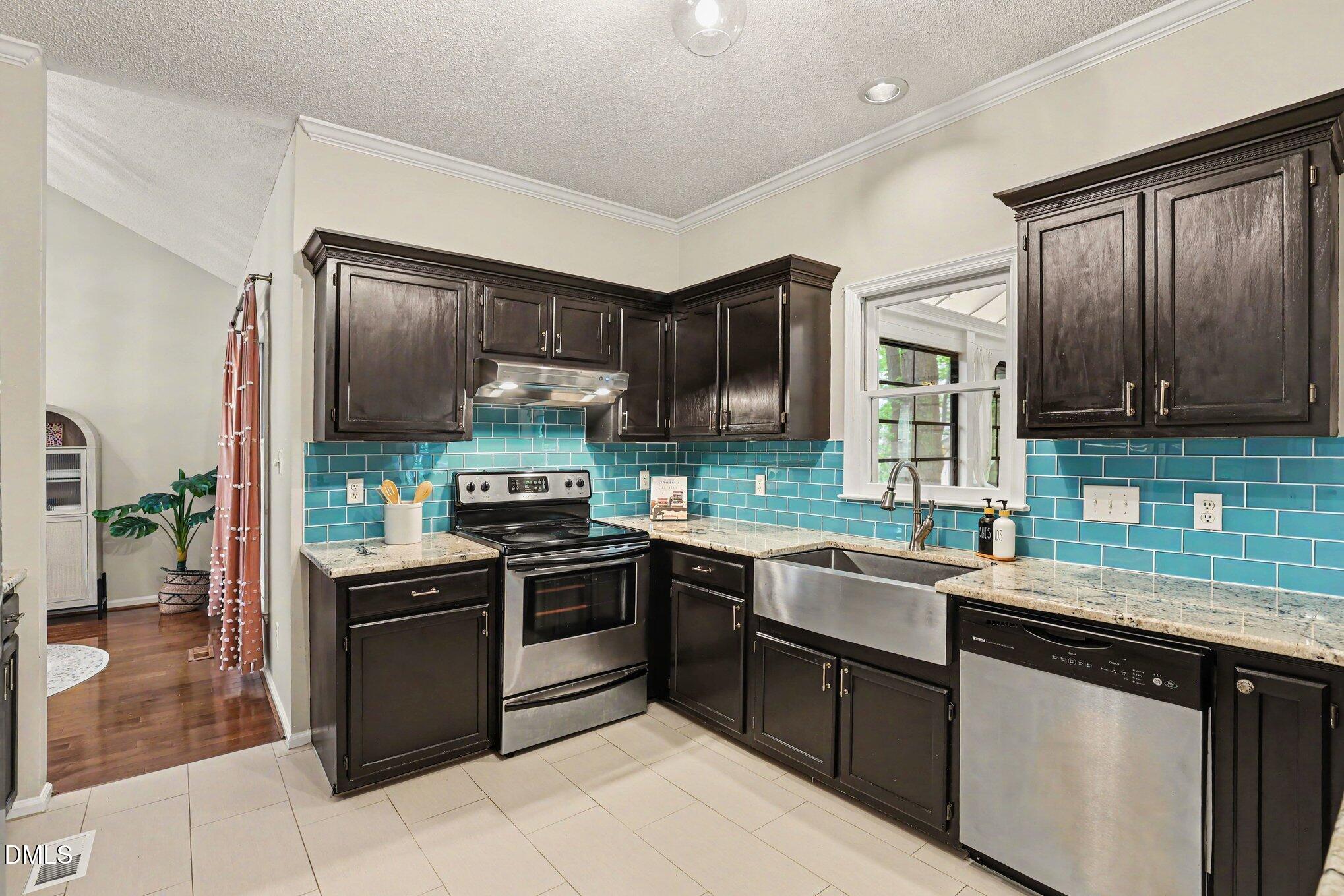 5468 Ingate Way Raleigh, NC 27613 - Photo 5 of 24 a kitchen with stainless steel appliances granite countertop wooden cabinets a sink a stove a refrigerator and island with wooden floor