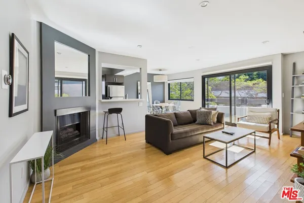 a living room with fireplace furniture and a large window