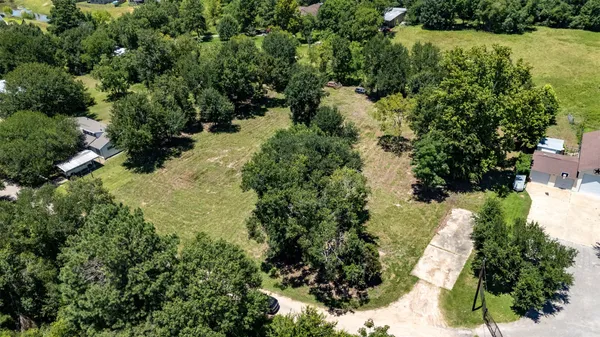 an aerial view of residential house with outdoor space and trees all around