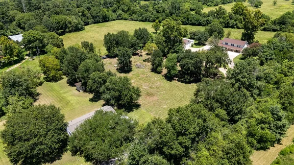 an aerial view of residential house with swimming pool and green space