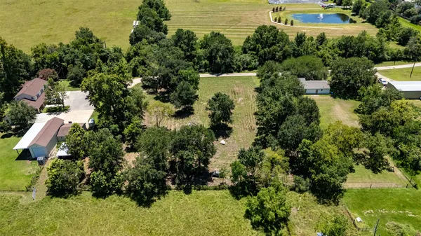 an aerial view of residential house with outdoor space and trees all around