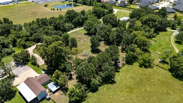 an aerial view of residential houses with outdoor space and trees