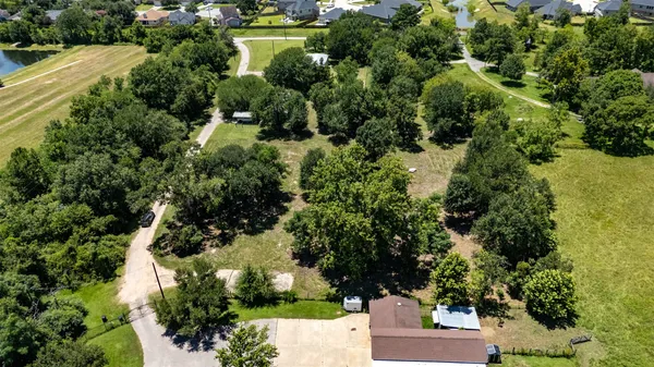 an aerial view of a house with a yard and lake view
