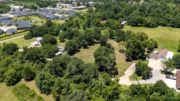 an aerial view of residential house with outdoor space and trees all around